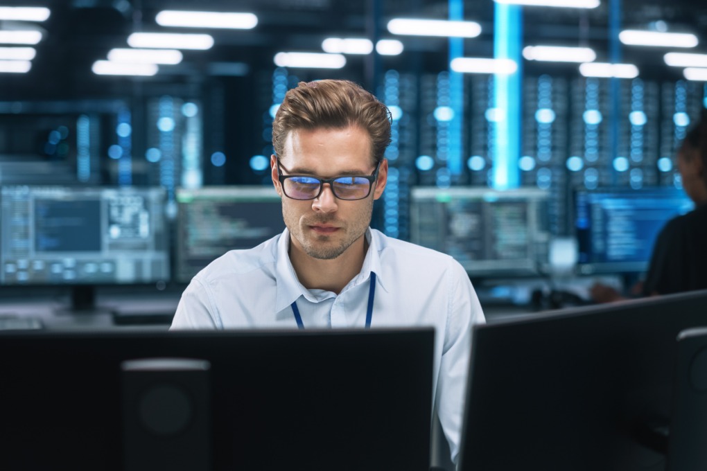 Night Office: Young Caucasian Man Working on Two Desktop Computers. Digital Entrepreneur Typing Code, Creating Modern Software, e-Commerce App Design, e-Business Programming