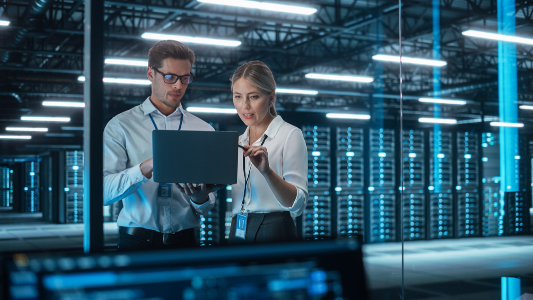 Male CEO Discusses Problem Solving with Female Partner in Office, They Brainstorming while Look on a Laptop. Smart Businesspeople Working in Finance. Specialists Work in Team Concept