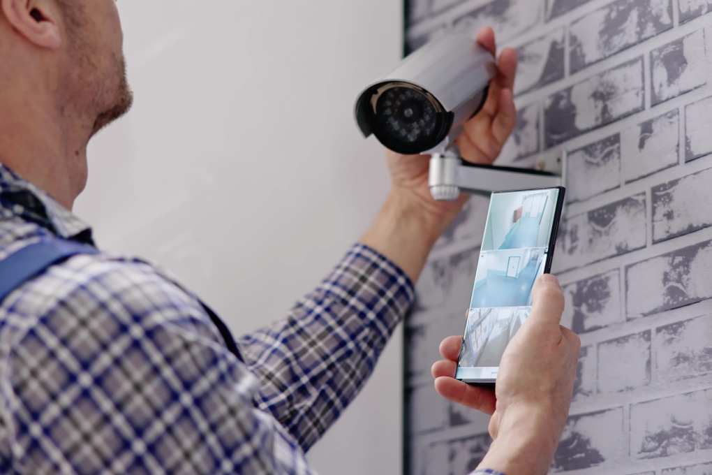 Engineers adjusting security surveillance system with CCTV technician